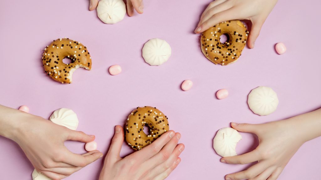 People Holding Delicious Food on Pink Surface