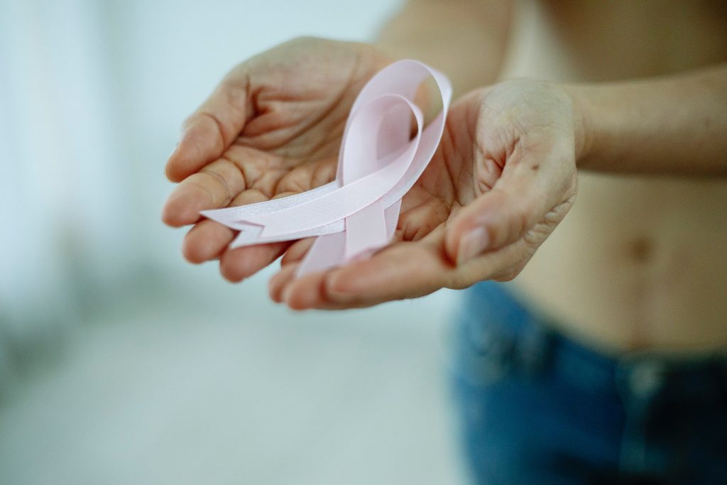 Anonymous topless woman with pink ribbons against breast cancer