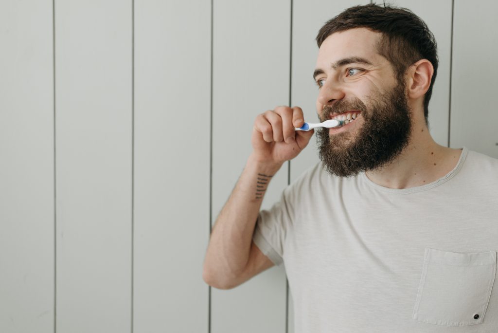 Man in White Shirt Brushing Teeth